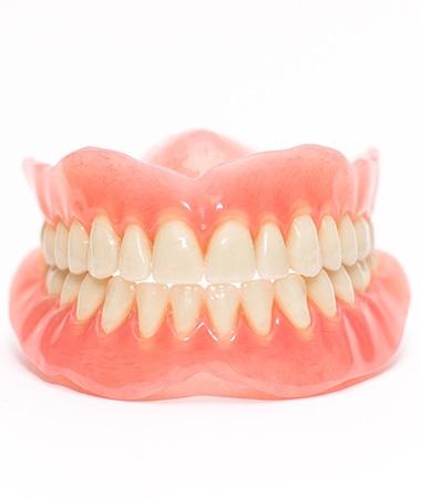 Full set of dentures on white background