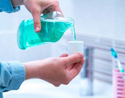 Woman pouring mouthwash in cap