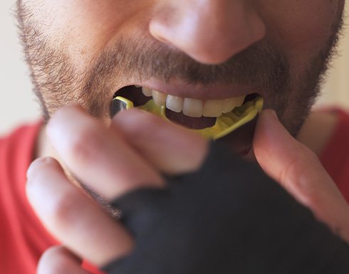 Man putting yellow and black mouthguard on