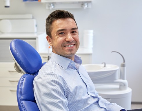 Man smiling while sitting in treatment chair