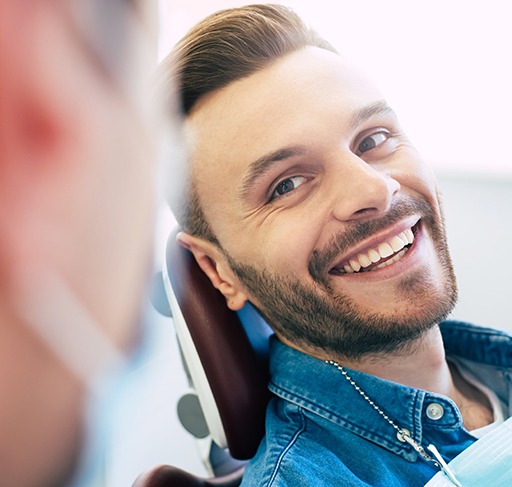 Man smiling at dentist while sitting in treatment chair